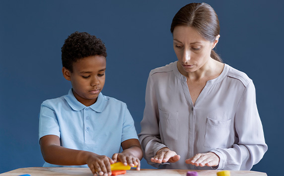 Interventionist working with a young student using manipulatives